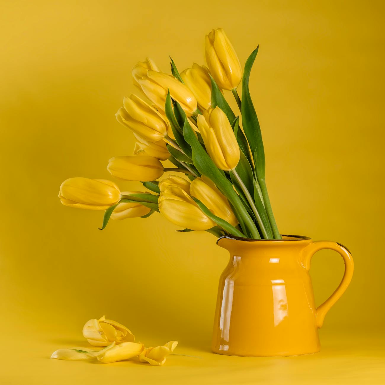 yellow tulips in yellow ceramic vase