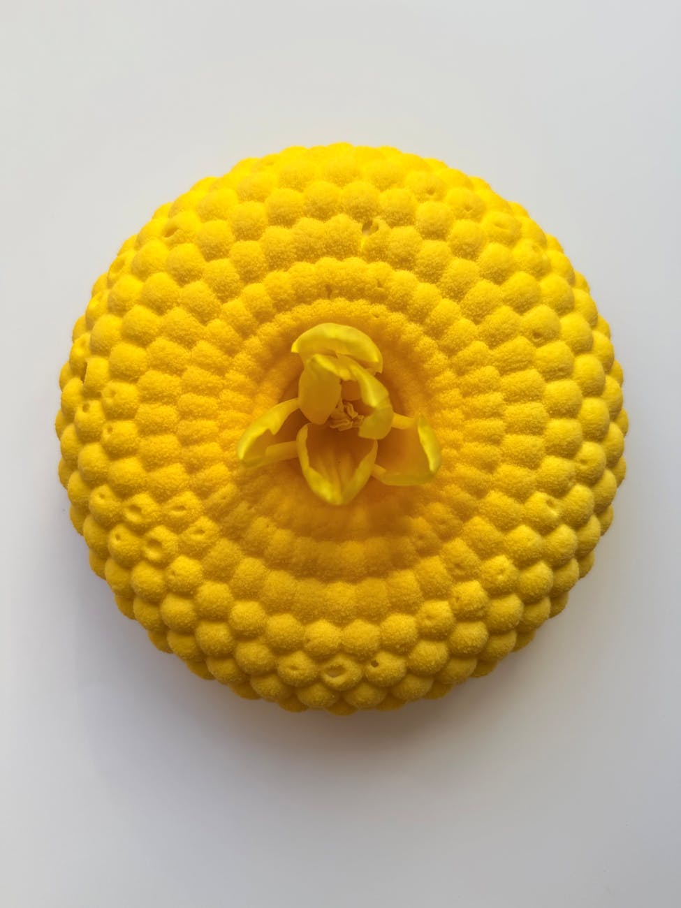 intricate yellow circular sculpture on white background