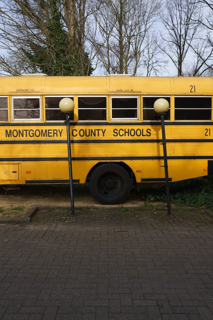 a yellow school bus parked beside the street lamps