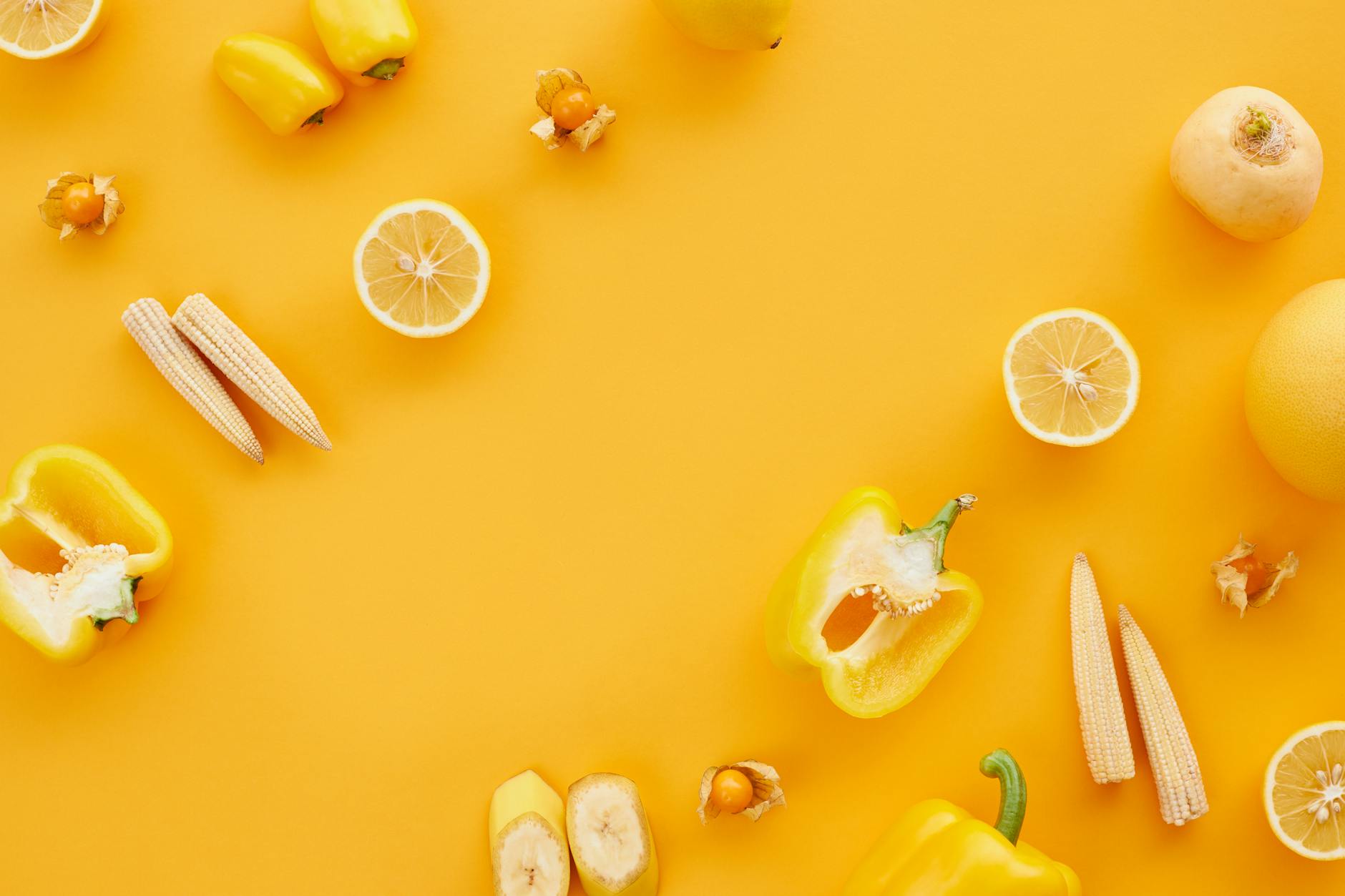 close up shot of yellow fruits and vegetables on a yellow surface