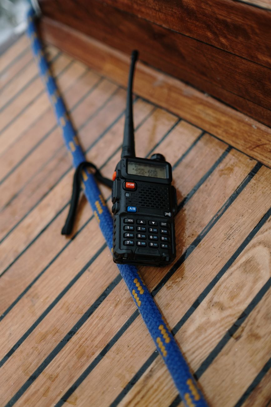 a two way radio on brown wooden surface