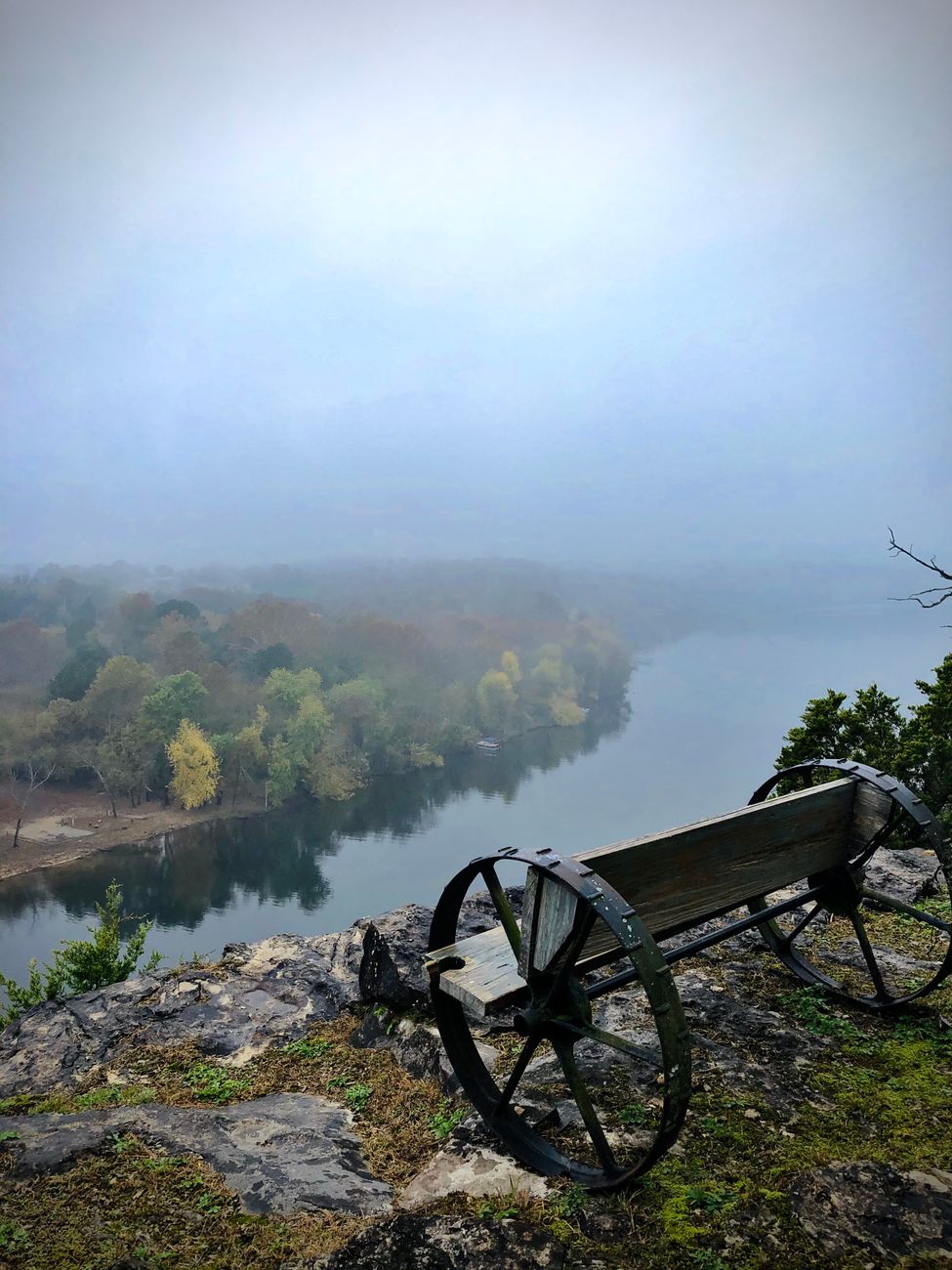 a wagon wheel bench overlooking a lake