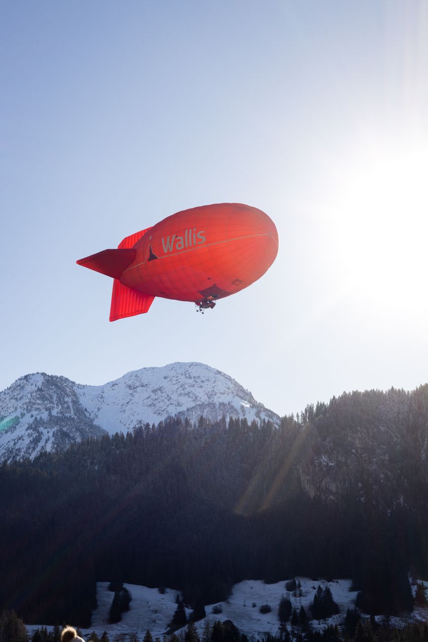 red airship over snowy swiss alps in chateau d oex